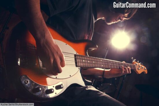 An electric bass guitar being played.